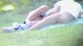 Un voyeur filme un couple qui baise dans un pré