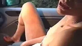 Femme dans une voiture se masturbe les cuisses écartées